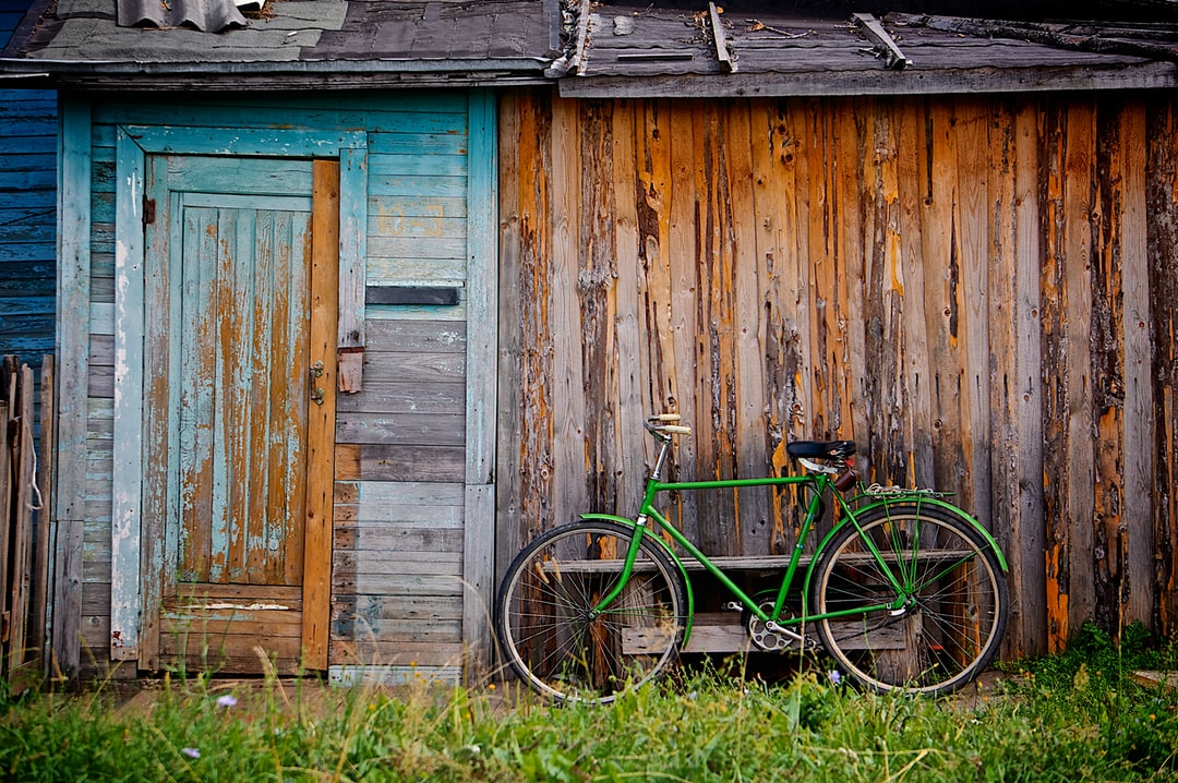 A bicycle parked in front of a wooden fence