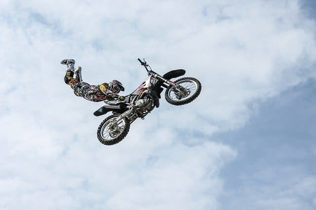 A man flying through the air while riding a motorcycle